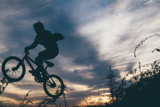 Ausriss eines BMX-Fahrrades mit einerPerson darauf, in der Luft